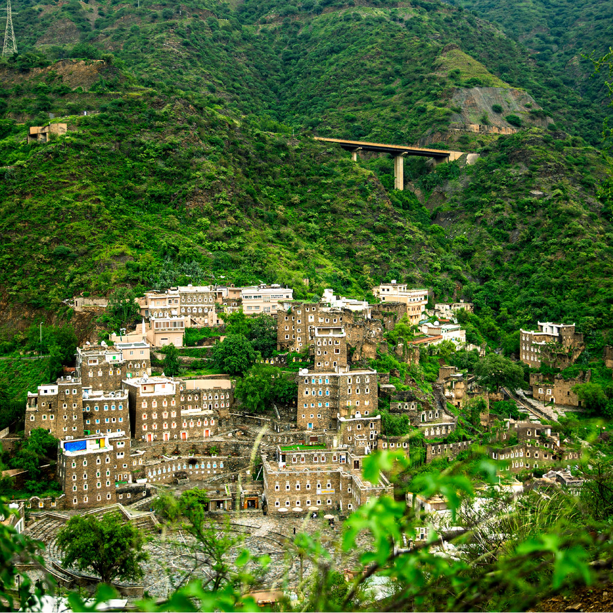 View over a city in the middle of the mountains with plantage around.